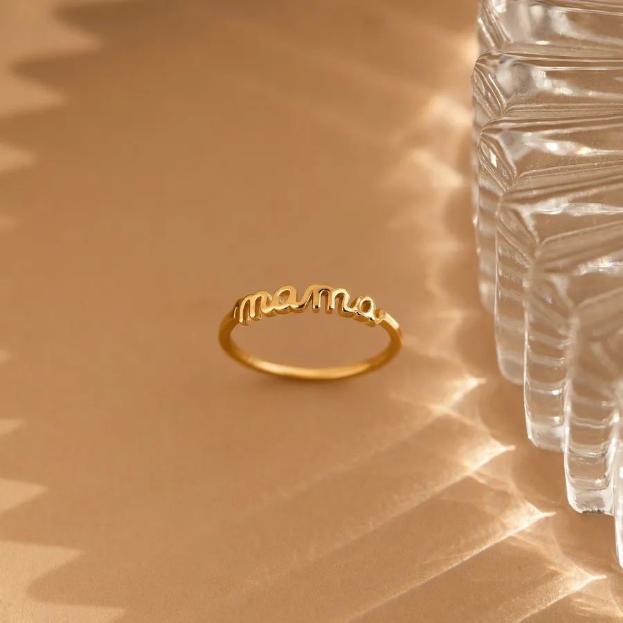 The Dainty Mama Ring with mama in cursive beside a textured glass