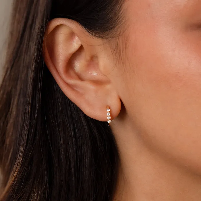 Close-up of an ear wearing Mini Birthstone Beaded Huggies