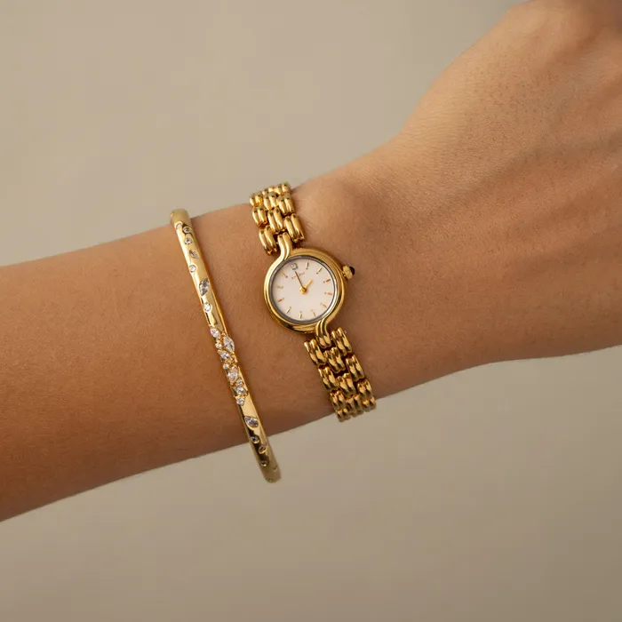 Vintage Citizen Round Ornate Gold Watch on a wrist beside a gold bangle