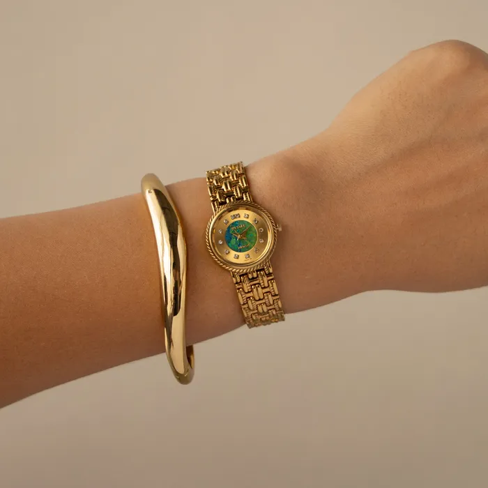 Vintage Westar Blue Green Dial Gold Watch on a wrist beside a gold bangle